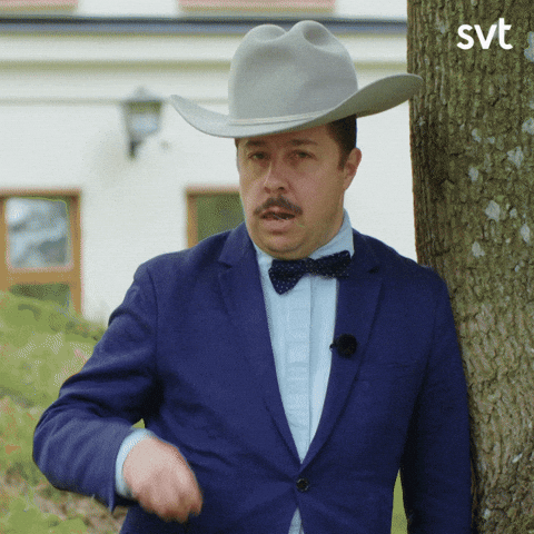 Man in tuxedo tipping cowboy hat